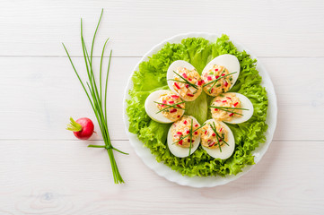 Stuffed eggs on lettuce with chives garnish - 62151031