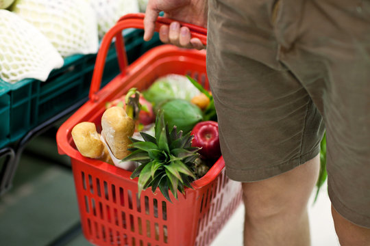 man with basket full of food in supermarket