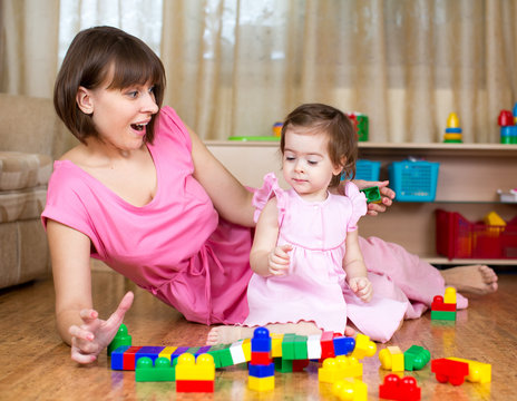 mom and child play with toys at home