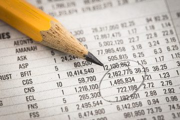 Pencil on world currency figures