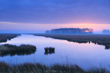 Purple, spring sunrise at a river.