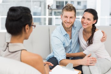Smiling couple reconciling at therapy session - obrazy, fototapety, plakaty