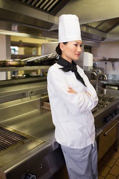 Thoughtful female cook standing in kitchen