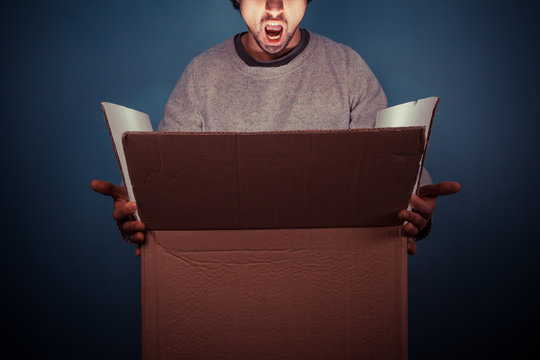 Surprised Young Man Opening Exciting Box