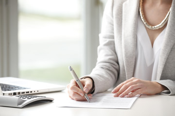 Close-up of businesswoman fill the form.