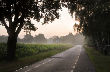 Country road with farm at sunrise
