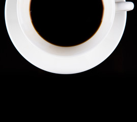 Coffee in a white cup over black background