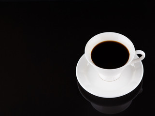 Coffee in a white cup over black background