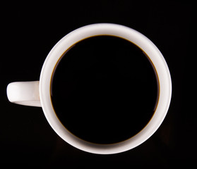 Coffee in a white mug over black background