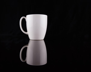 Coffee in a white mug over black background