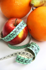 Fruits and measurement tape on the white background