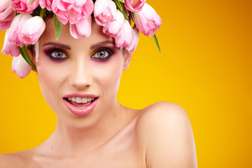 Portrait of a beautiful spring girl wearing flowers hat. Studio