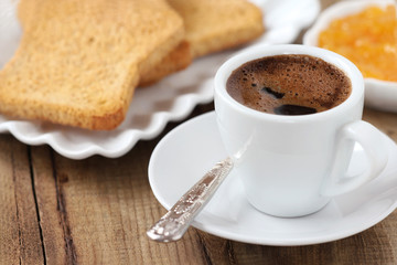 Breakfast concept - cup of black coffee with toasts and jam