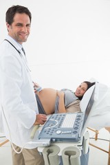 Fototapeta na wymiar Doctor performing ultrasound on expectant woman