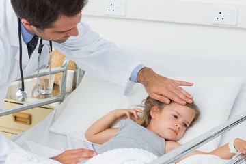 Doctor checking temperature of sick girl