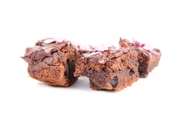 Slices of a brownie covered with chocolate and decorated with sugar hearts