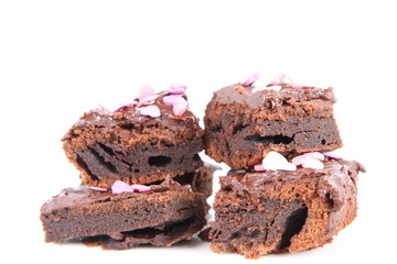Slices of a brownie covered with chocolate and decorated with sugar hearts