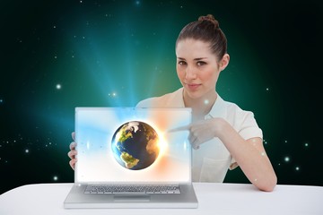 Businesswoman pointing to her laptop showing earth graphic