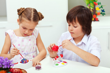 Boy and girl painting easter eggs
