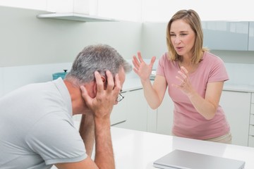 Unhappy couple having an argument in kitchen