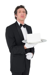 Confident waiter holding tray against white background