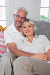 Relaxed mature couple sitting on sofa in living room