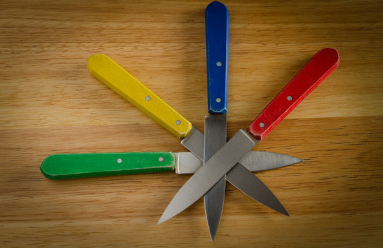 knives on wood, red, yellow, blue, green
