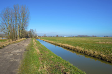 Fototapeta na wymiar Canal along a road towards a river in winter