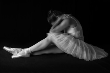 Female dancer sit on floor looking sad in artistic conversion