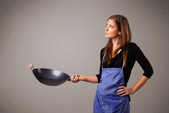 Young lady holding a frying pan