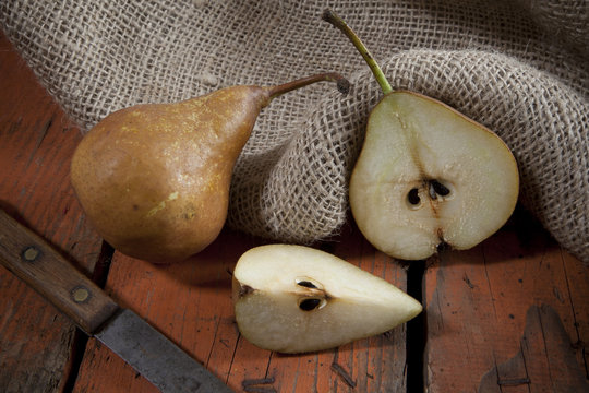 pears on woody rustic table with jute sack