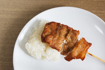 Grilled pork barbecue with sticky rice in a white dish