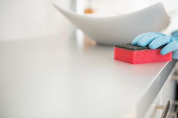 Closeup on young woman cleaning desk in bathroom