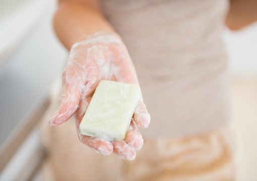 Closeup on young woman showing soap bar