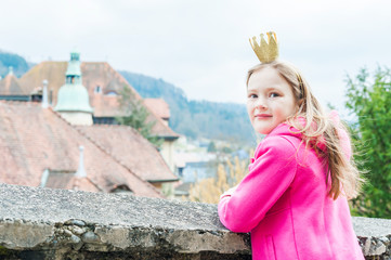 Cute little girl playing in a park, wearing princess crown © annanahabed