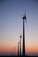 Obraz premium Silhouette of a Windfarm during sunset