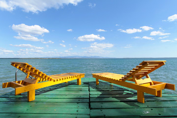 Fototapeta premium Chaises longues en bois et horizon