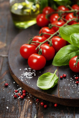 Tomatoes with basil on wooden table background