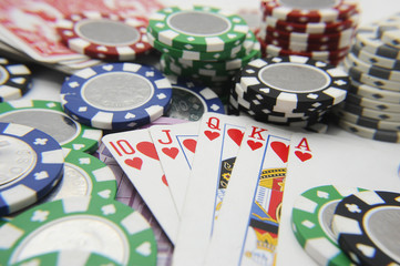 Royal flush poker hand with poker chips stack
