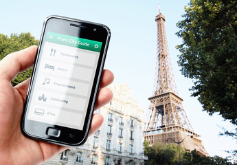 Hand holding smartphone with city guide in Paris