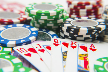 Royal flush poker hand with poker chips stack