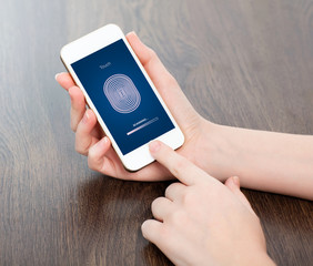 female hands holding a phone and entering the PIN code of finger