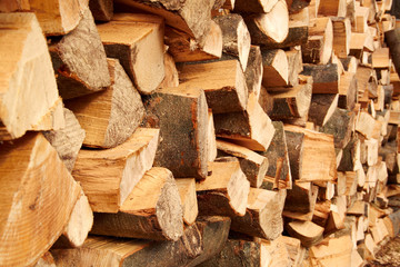 Background of dry chopped firewood logs stacked up on top of