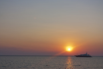 Obraz premium sunset with a yacht moored in the sea