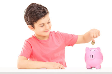 Boy putting money into a piggybank