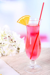 Glass of cocktail on table on light background