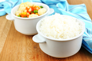 Cooked rice with vegetables on wooden table close up