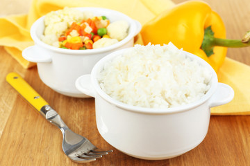 Cooked rice with vegetables on wooden table close up