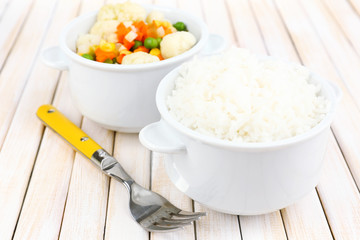 Cooked rice with vegetables on wooden table close up