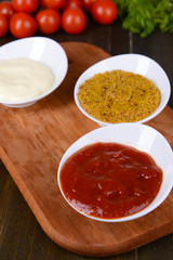 Various sauces on chopping board on table close-up